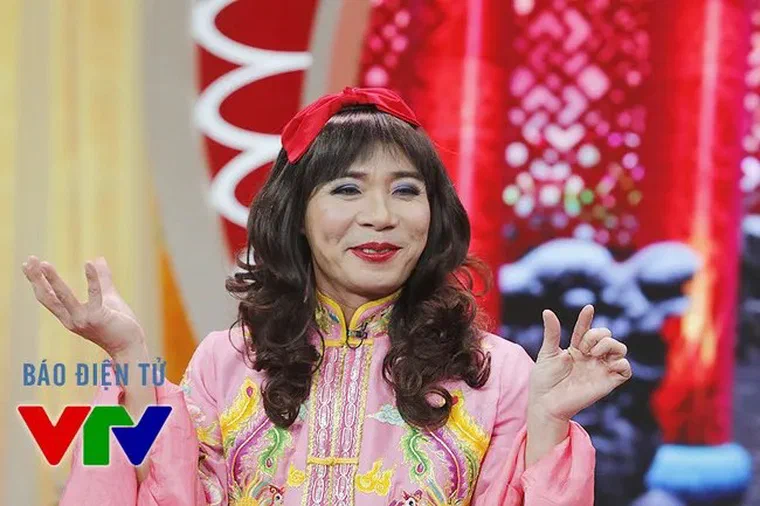 Công Lý trong vai Bắc Đẩu, áo hồng thêu, tóc giả nâu sẫm xoăn bồng dài quá vai, mái bằng, cài nơ đỏ trên đỉnh