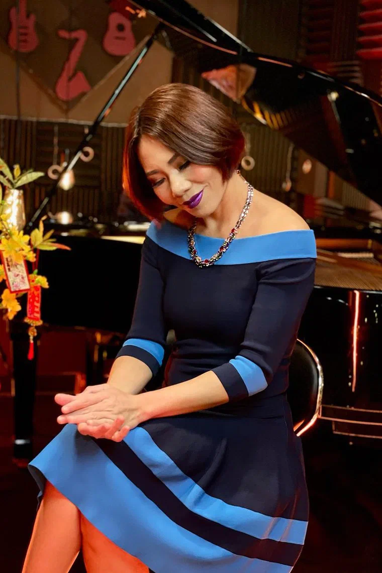 Hà Trần ngồi bên đàn piano, tóc bob suôn ngang cằm màu nâu hạt dẻ, mái dài rẽ lệch, đuôi tóc cụp vào trong