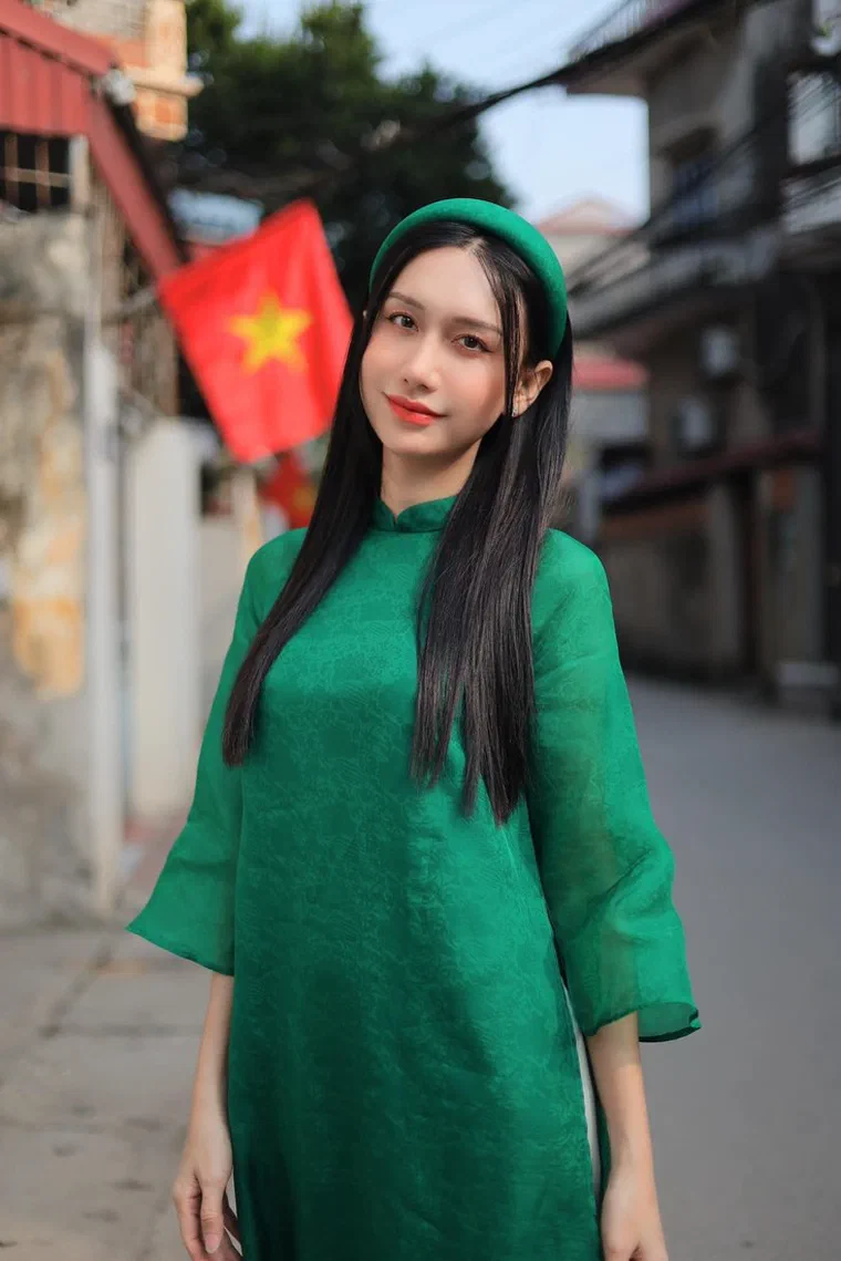 Lynk Lee mặc áo dài xanh lá, tóc đen thẳng dài cài bờm nhung xanh bản to