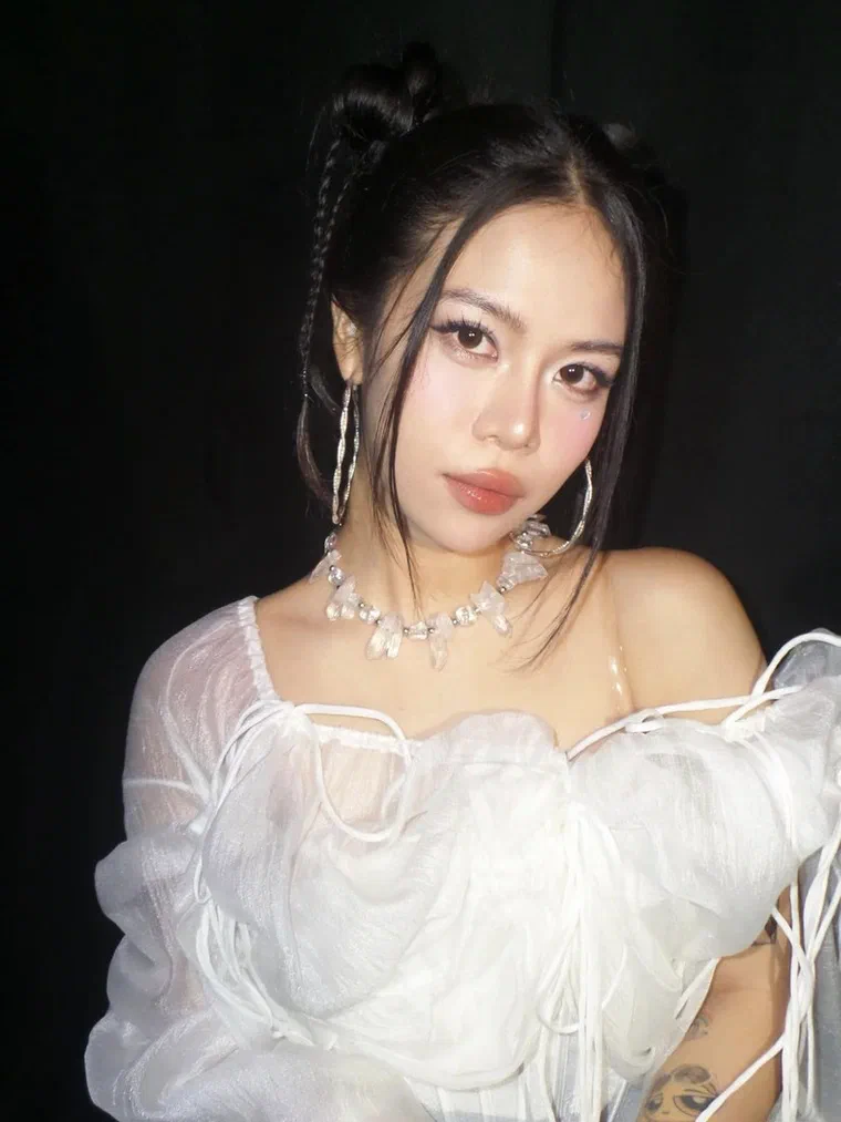 tlinh buộc tóc đen thành hai búi nhỏ trên đỉnh đầu, vài bím tết mảnh chạy dọc thái dương và các lọn con buông trước mặt